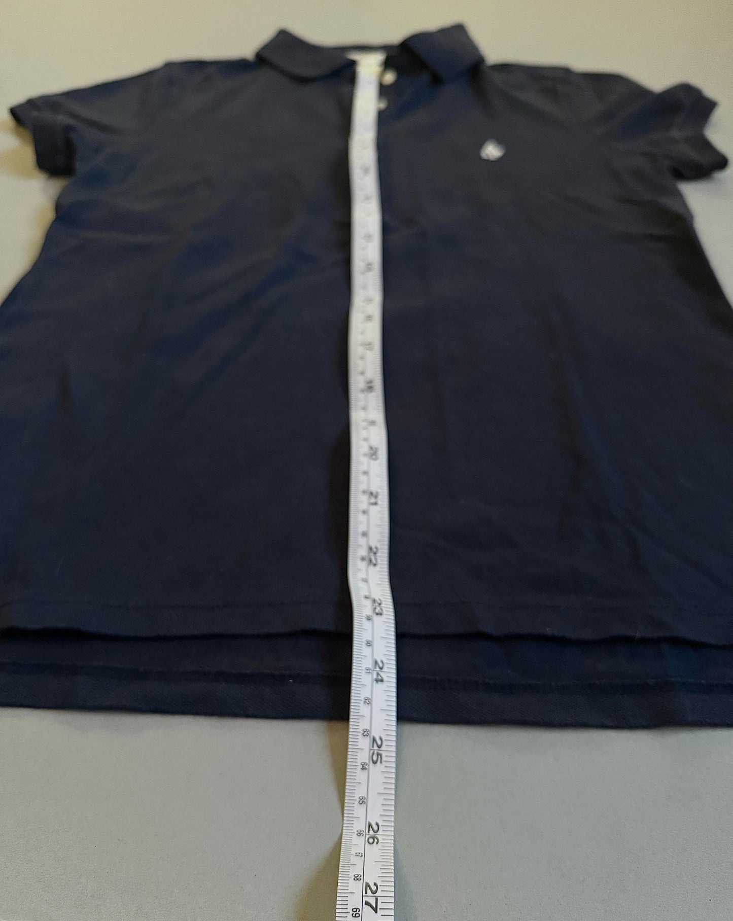 Abercrombje & fitch 2000s women’s navy polo with measuring tape showing 24 inches length.