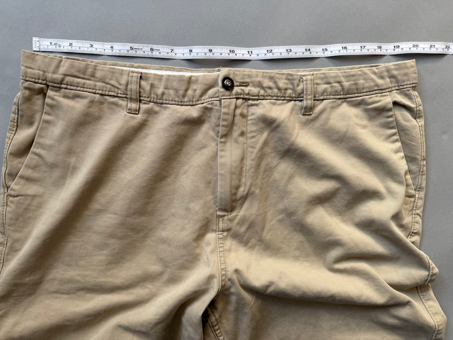 Men’s khaki DC chino skate shorts with measuring tape showing waist 19 inches (doubled = 38 inches)