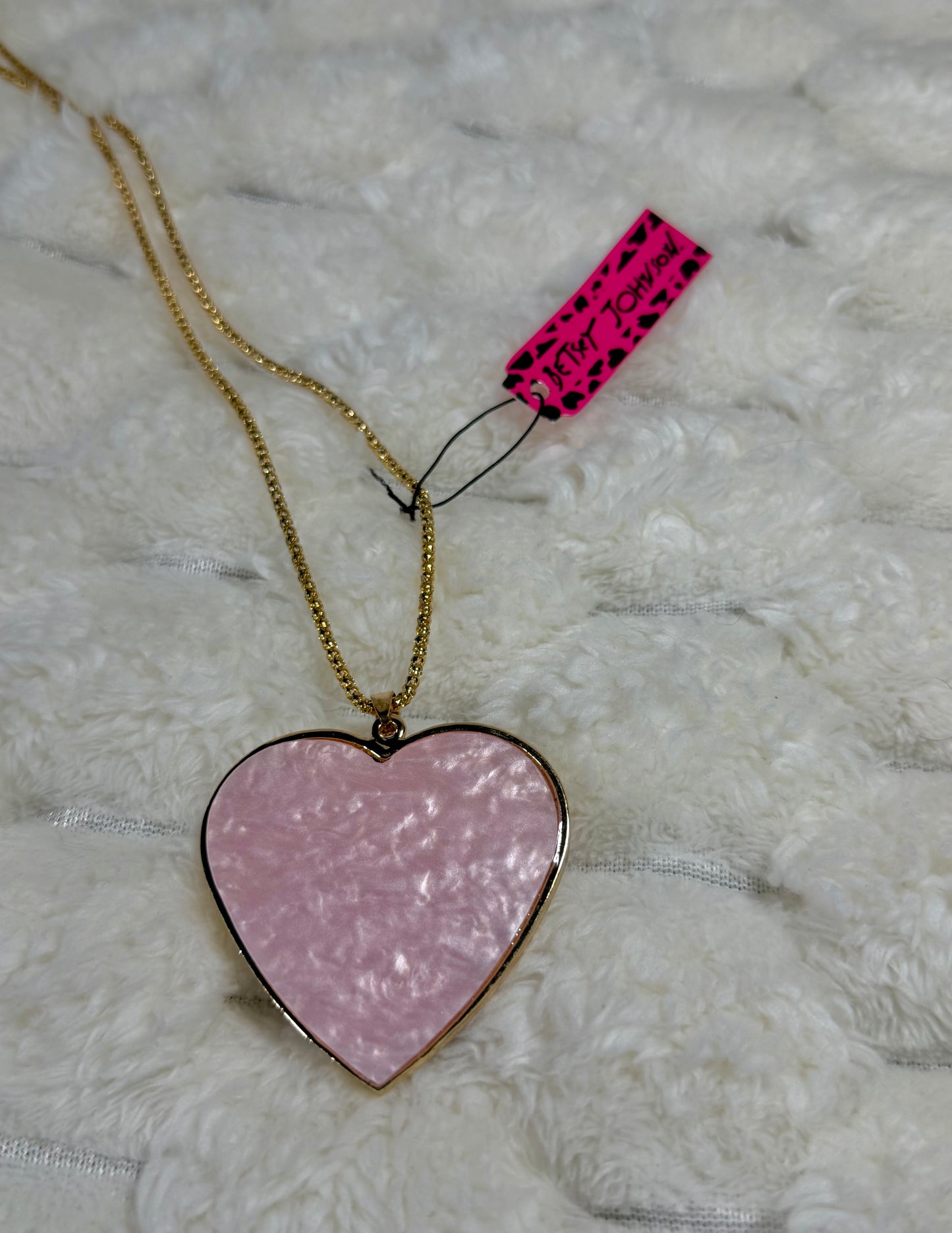 Back view of the Betsey Johnson heart pendant featuring a pearlescent pink enamel finish and gold-tone setting.