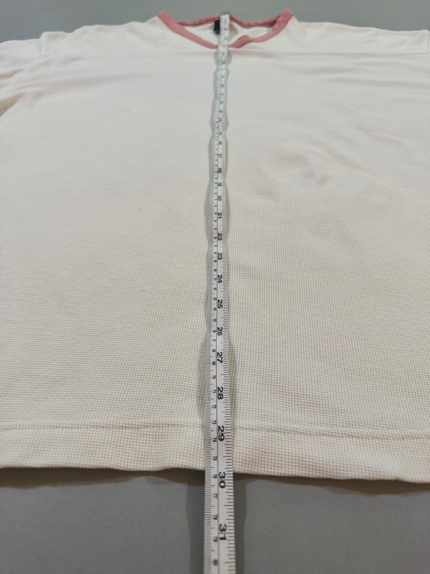 Vintage Levi’s 1999 waffle knit thermal shirt displayed flat with measuring tape showing overall length.
