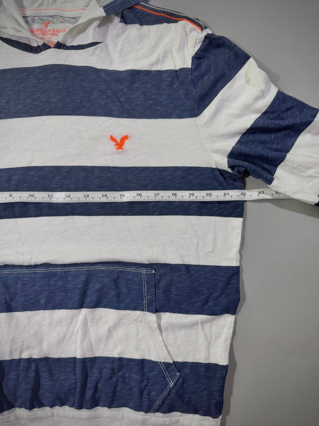 Close up view of men’s AE striped long sleeve, showing pit to pit measurement 