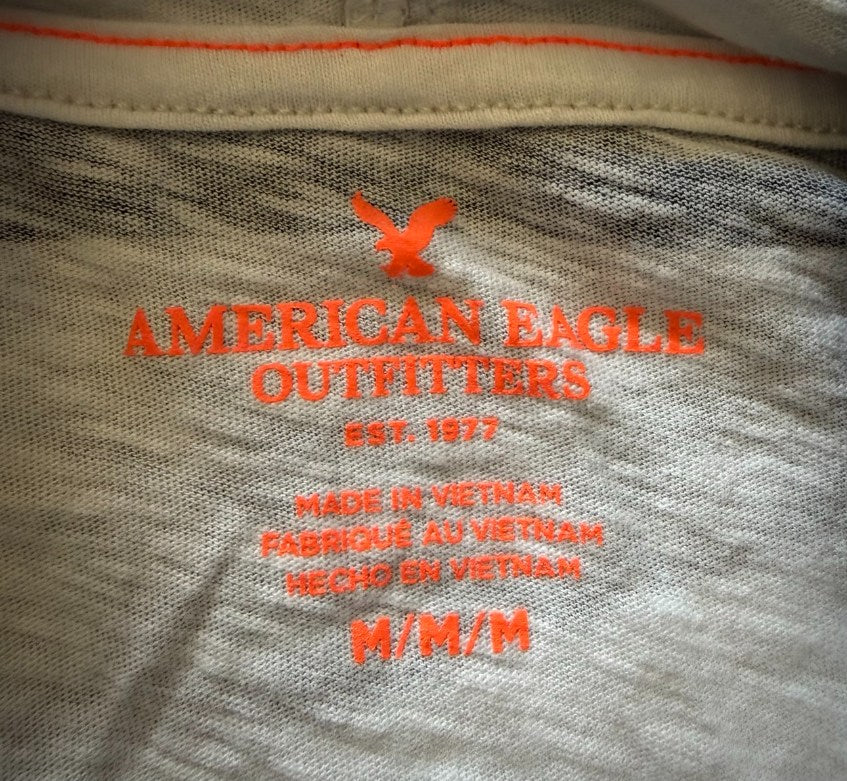 Printed neck tag of men’s American Eagle hooded shirt showing size medium. 