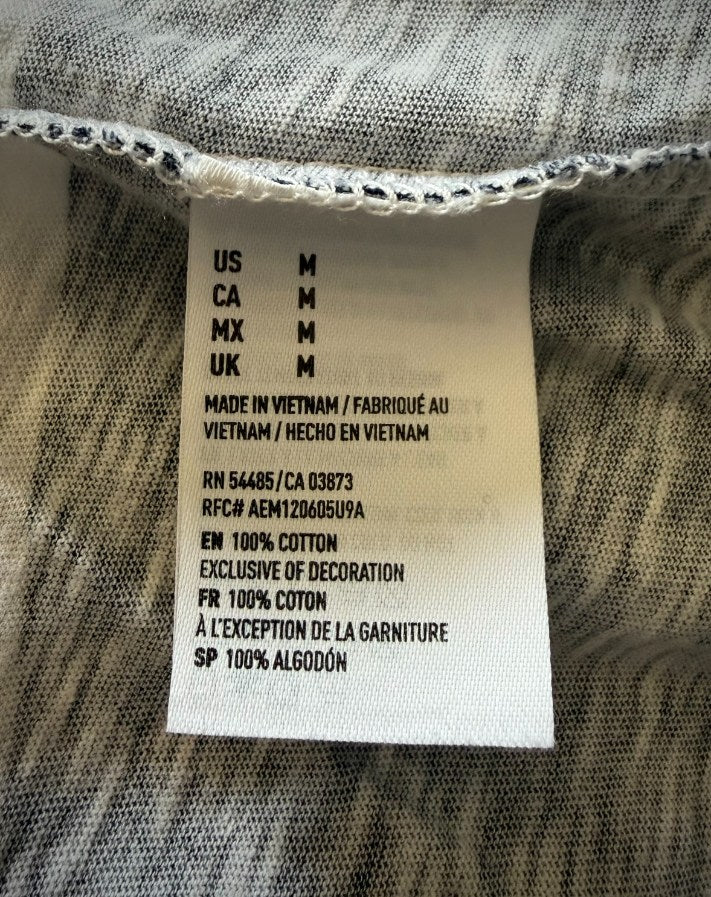 Close up of care tag on men’s Y2K American Eagle long sleeve tee showing 100% cotton. 