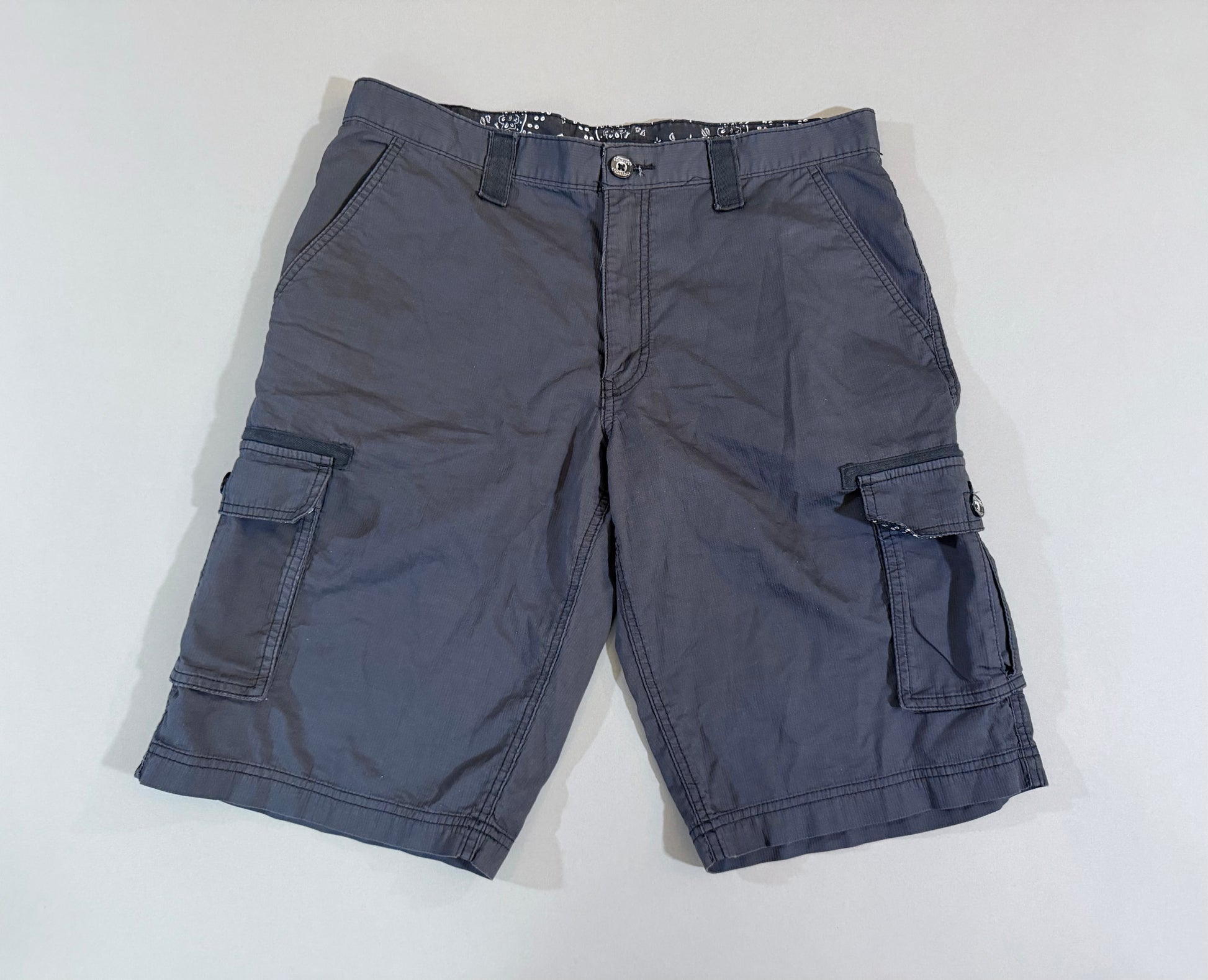 Front view of charcoal gray men’s cargo shorts with multiple utility pockets.