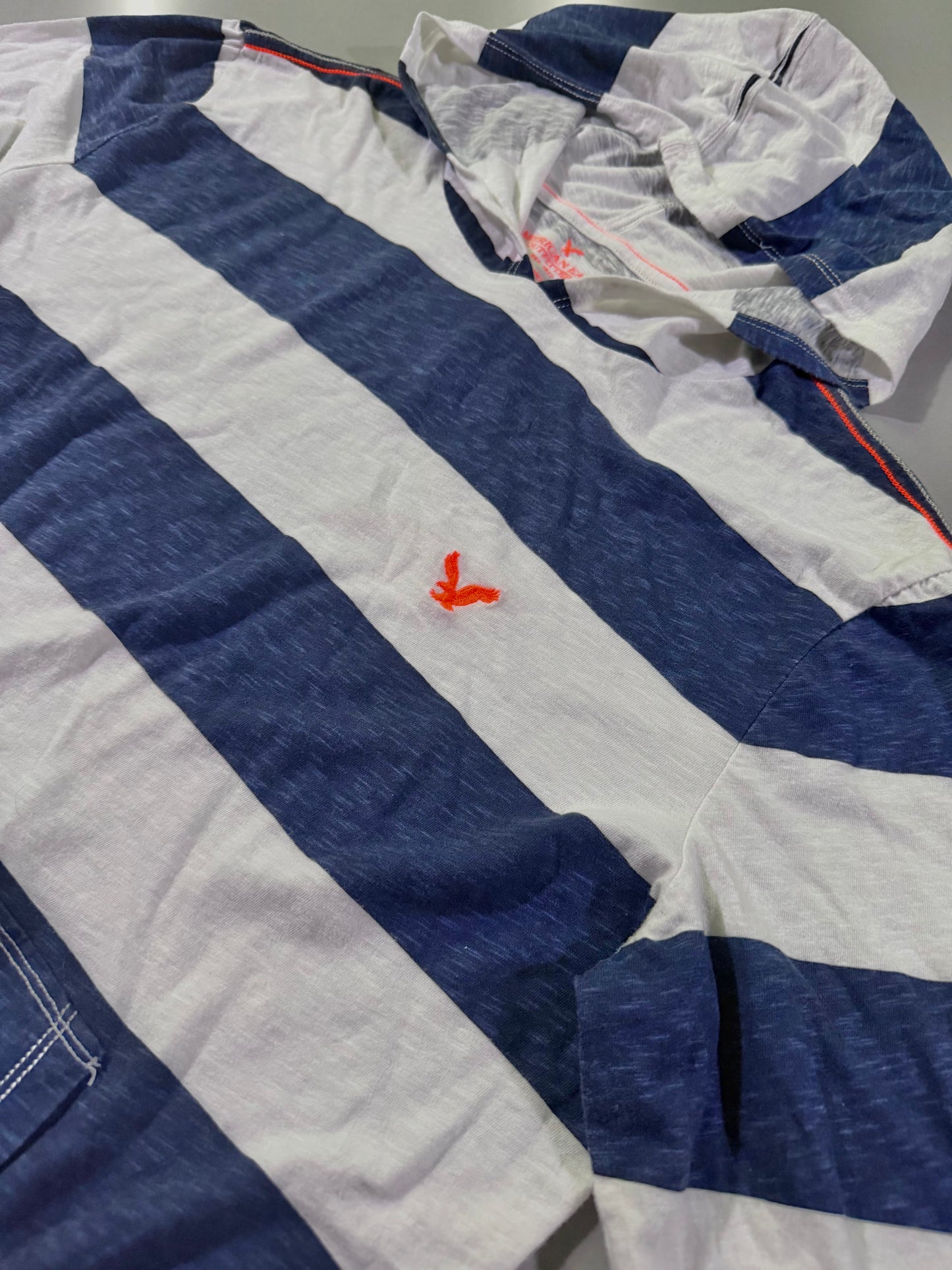 Angled view of American eagle hooded shirt from 2010, showing neon orange embroidered logo and contrast stitching. 