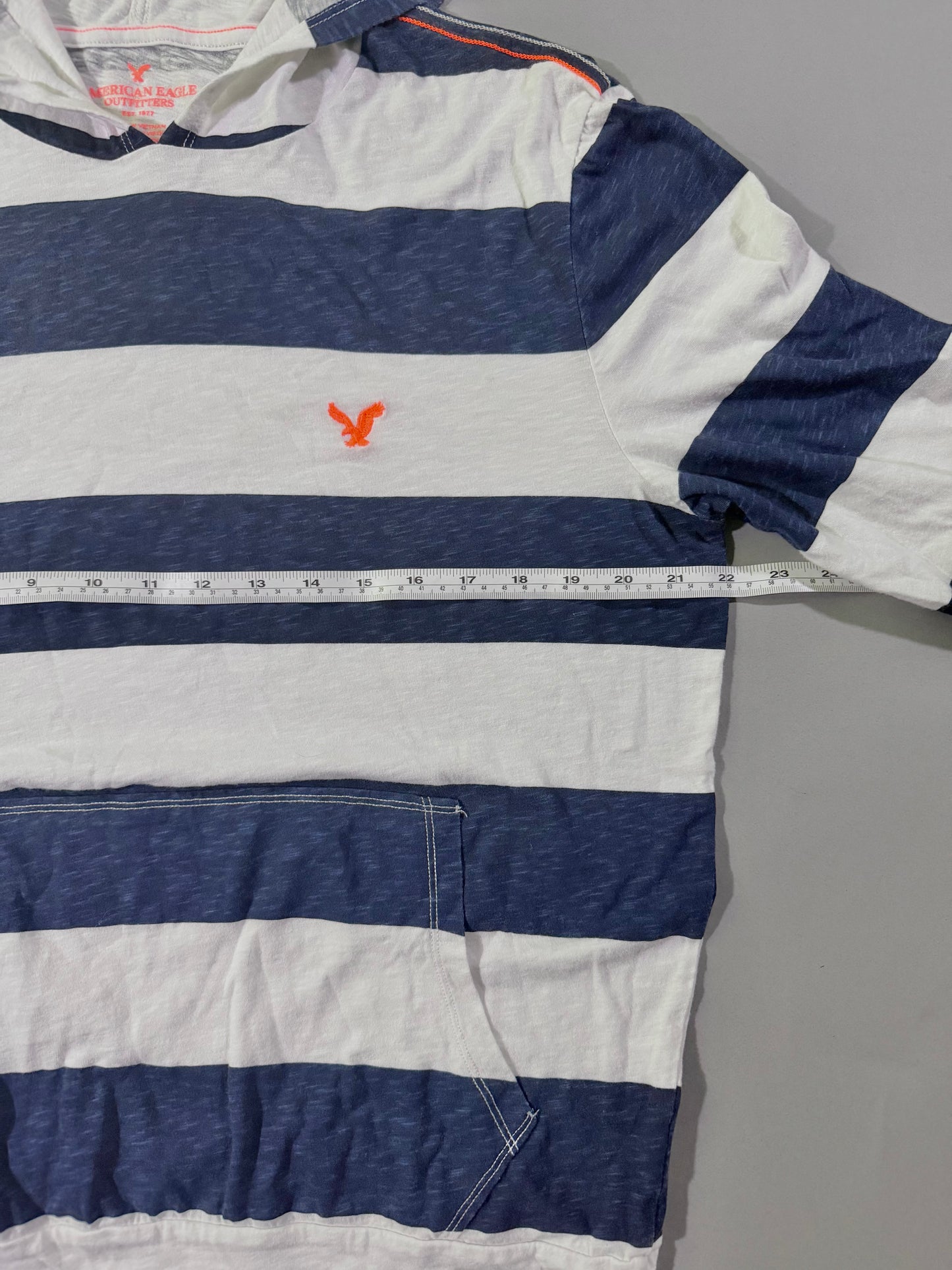 Close up view of men’s AE striped long sleeve, showing pit to put measurement 