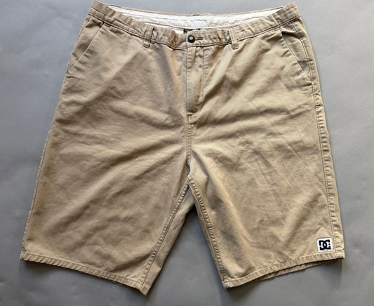 Men’s khaki DC chino skate shorts with small logo patch on bottom right hem 