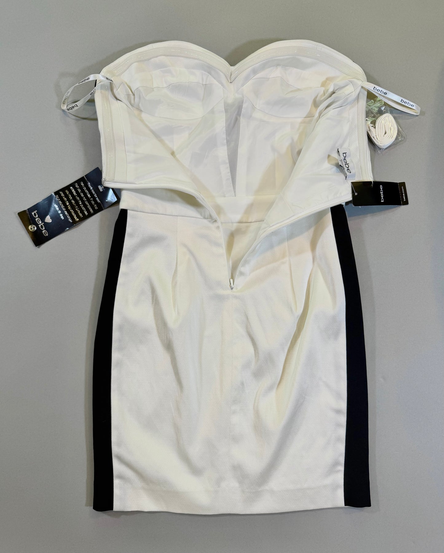 Back of Bebe dress showing zipper, corset style bust, and tags still attached