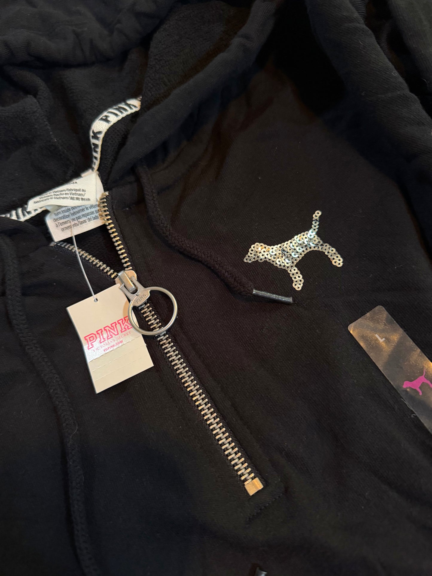 Close-up of the quarter-zip hoodie featuring the sequin PINK dog logo and original retail tags.