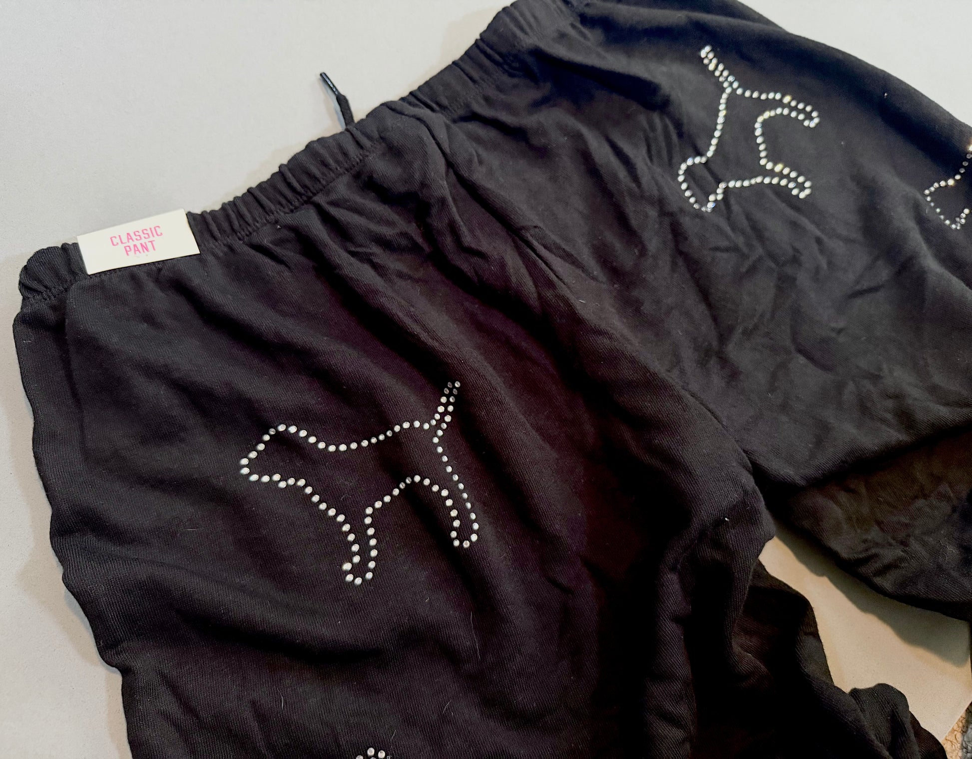 Close-up of the rhinestone dog graphic and original tag on the matching PINK sweatpants.