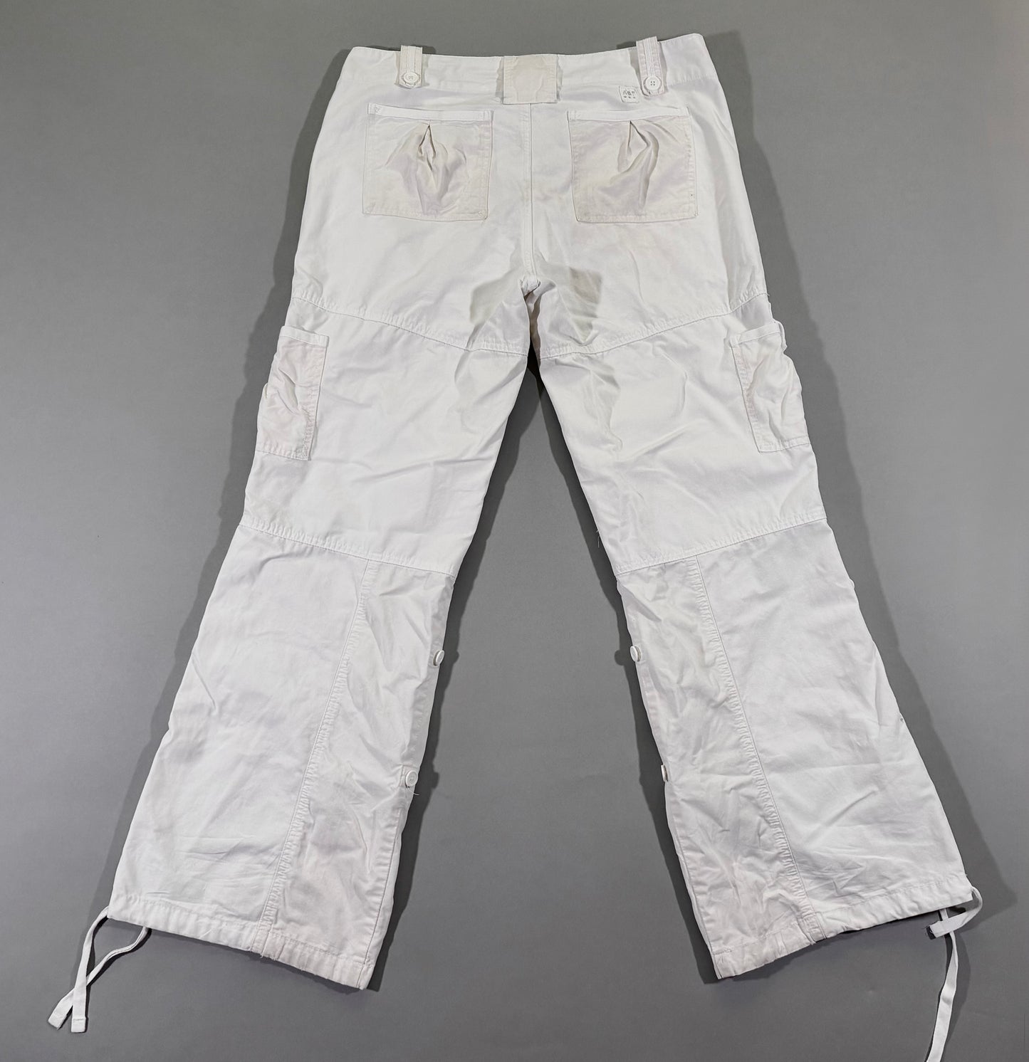 Back view of vintage Abercrombie & Fitch white cargo pants featuring oversized patch pockets, utility cargo pockets, and wide-leg silhouette.