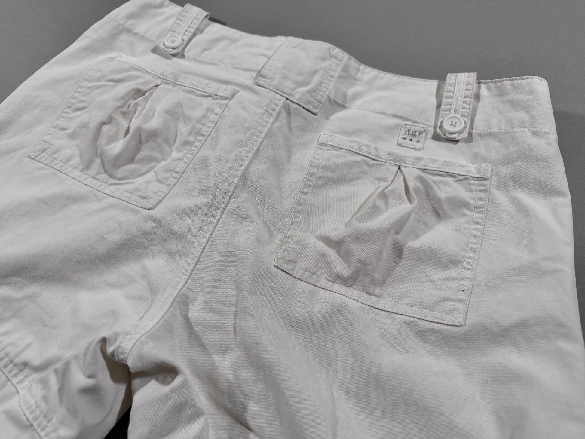 Close-up of the back waistband on vintage Abercrombie & Fitch cargo pants showing rear pockets, belt loops, and embroidered A&F logo tab.