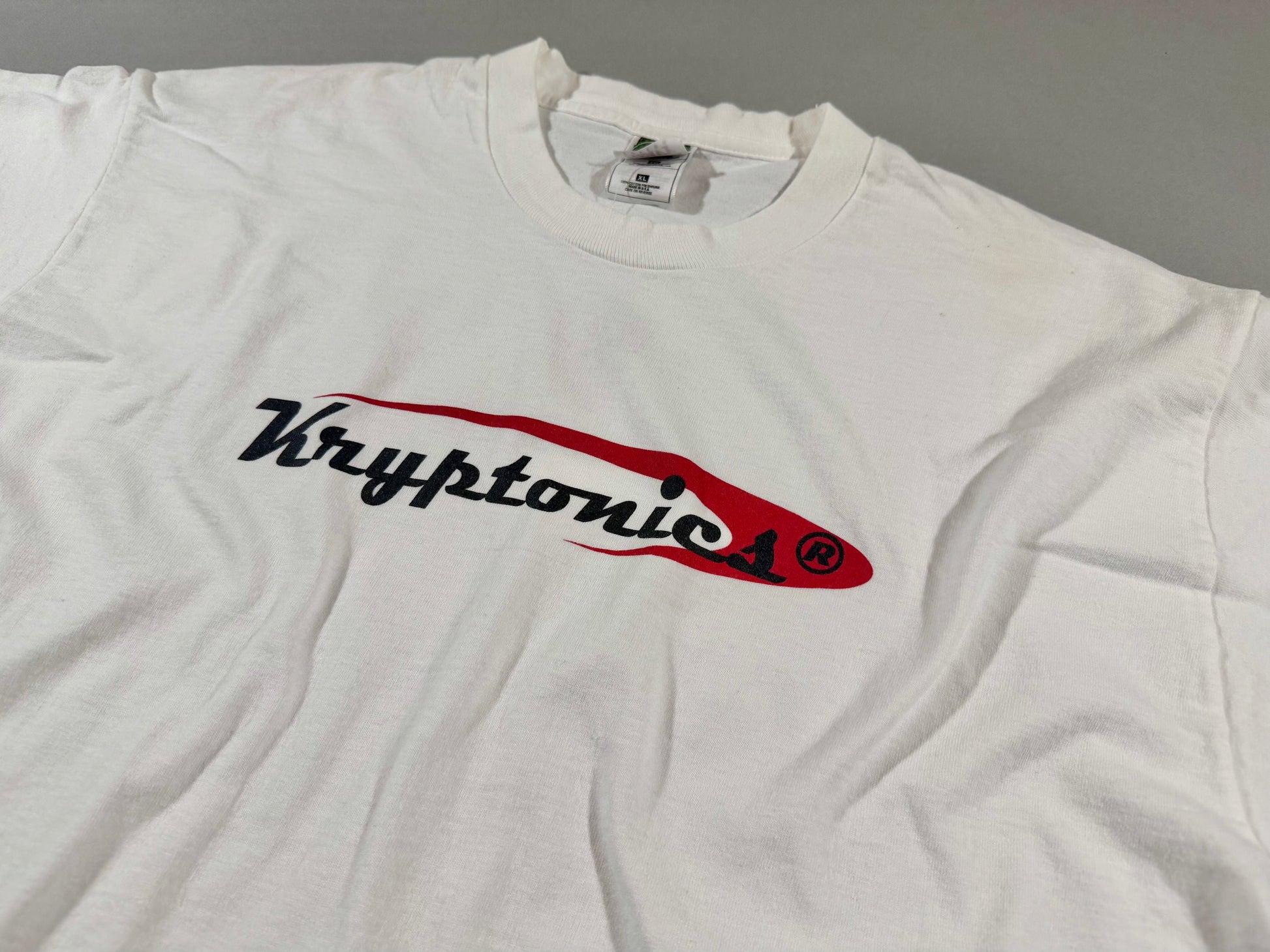 Close-up of vintage Kryptonics chest logo on white cotton T-shirt.