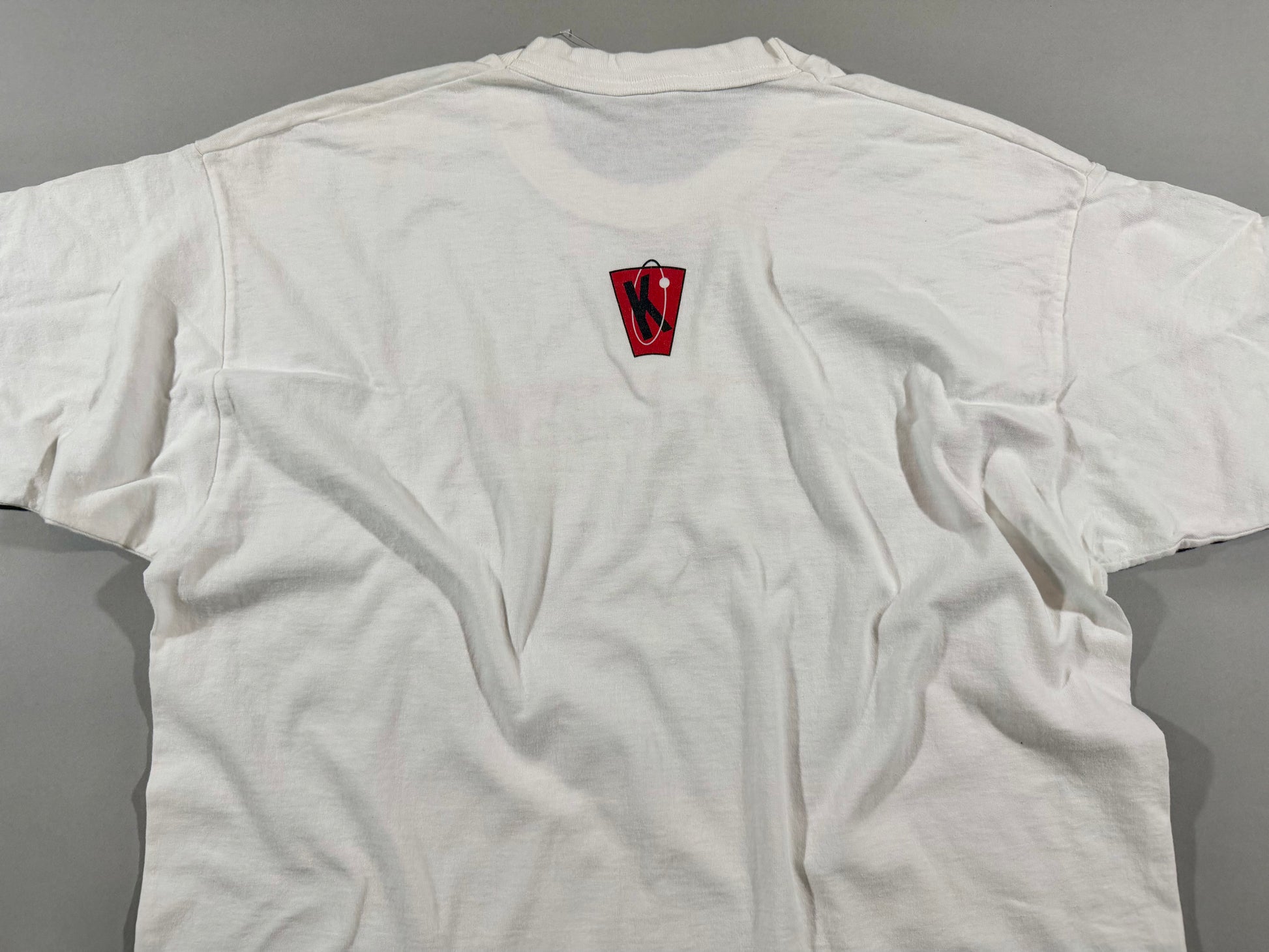 Back view of vintage Kryptonics white T-shirt featuring small red and black logo below the collar.