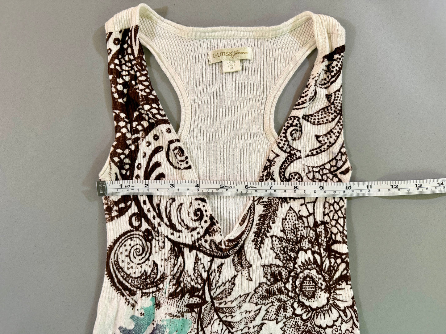 Close-up of the Guess Jeans dress label and racerback design with measuring tape showing 10 inches pit to pit. 