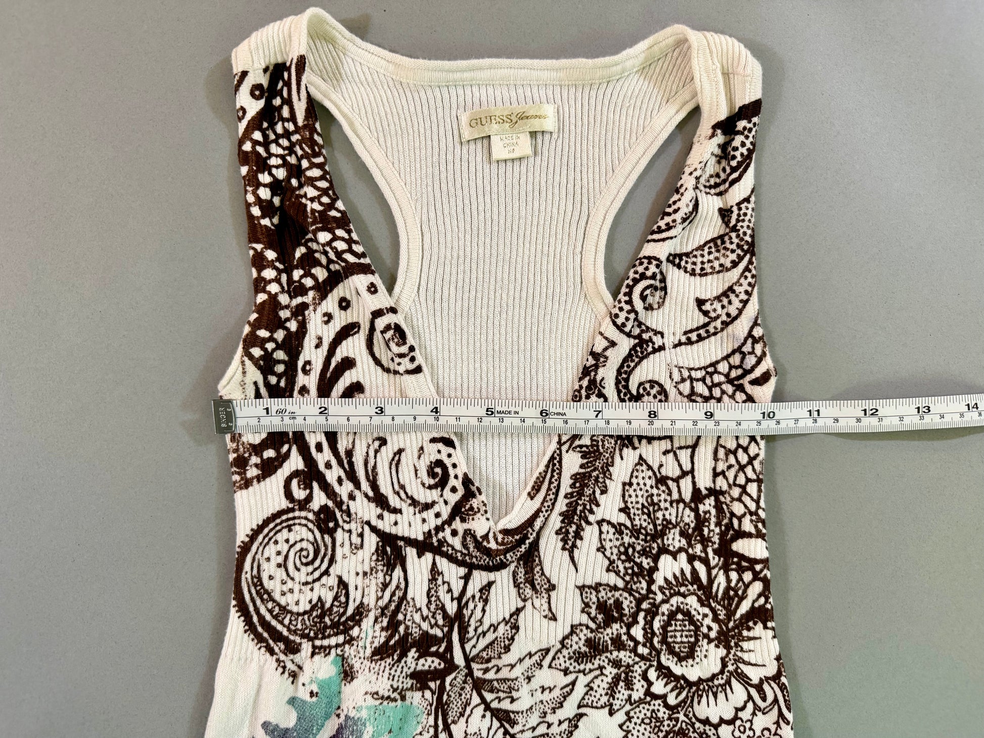 Close-up of the Guess Jeans dress label and racerback design with measuring tape showing 10 inches pit to pit. 
