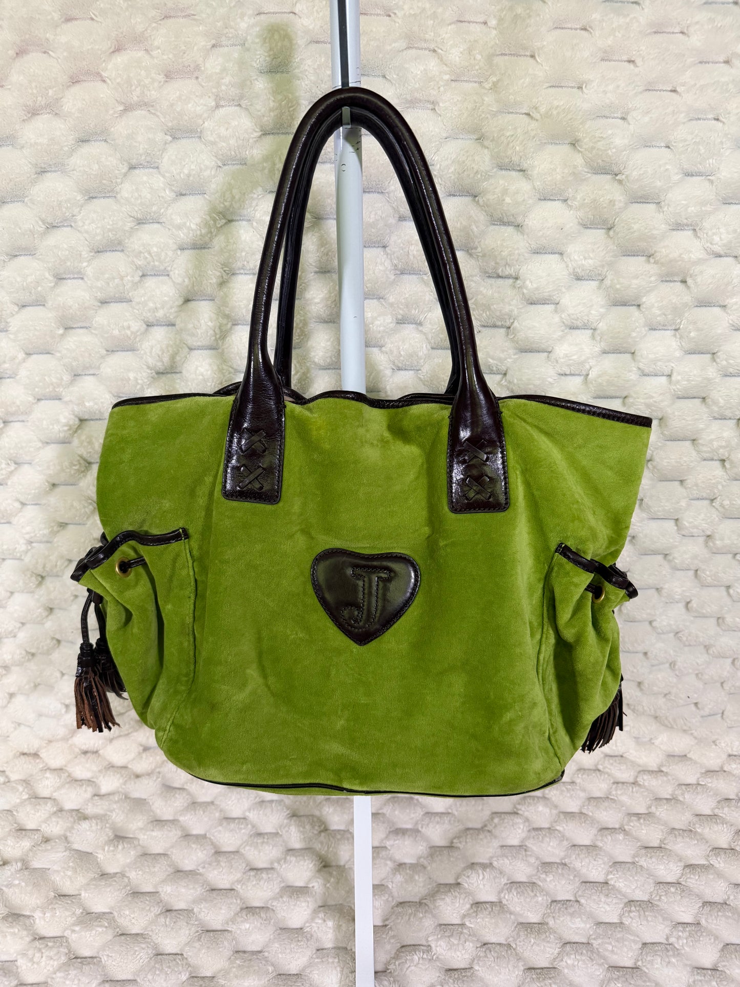 Back of vintage Juicy Couture green velour Splendor tote with brown leather-look trim, side pockets and heart logo patch.