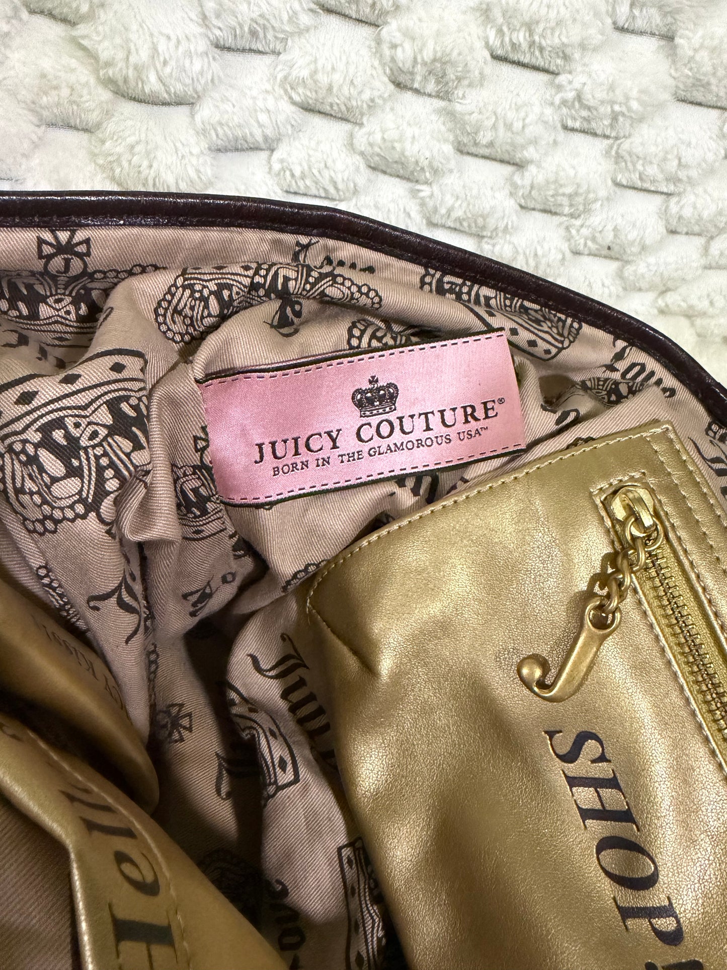 Interior of juicy couture purse showing novelty pockets and vintage pink garment tag from the 2000s.