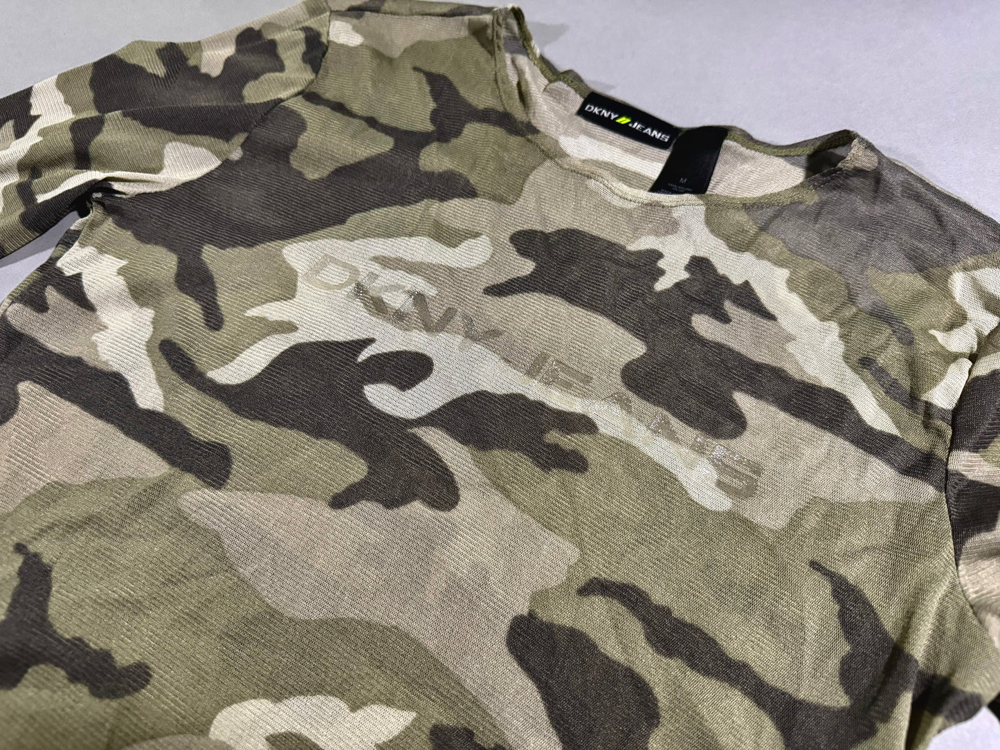 Close-up angled photo of y2k era mesh camo printed long sleeve shirt with subtle DKNY branding