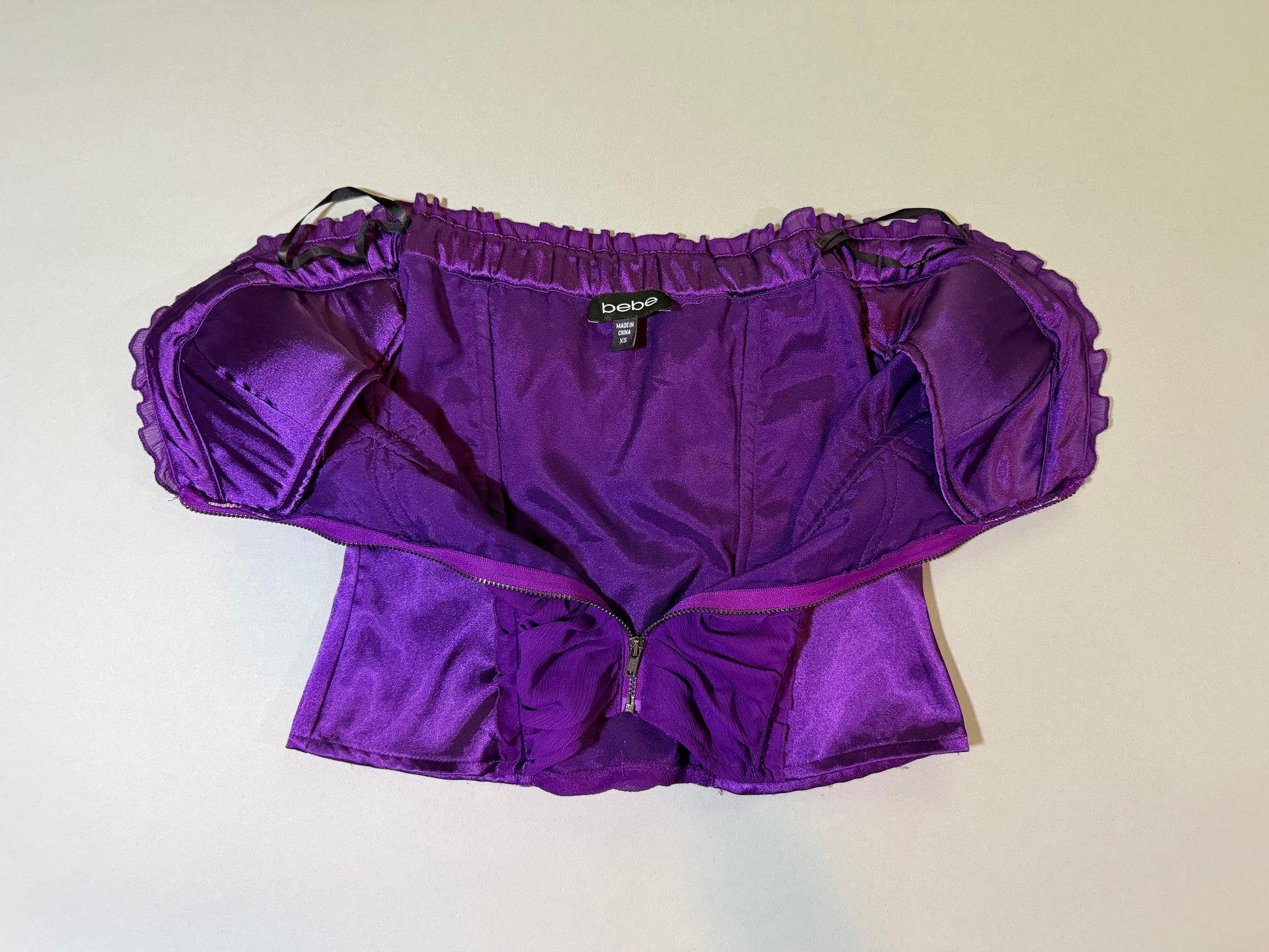 Front of Bebe top with middle zipper opened to show inside lining 