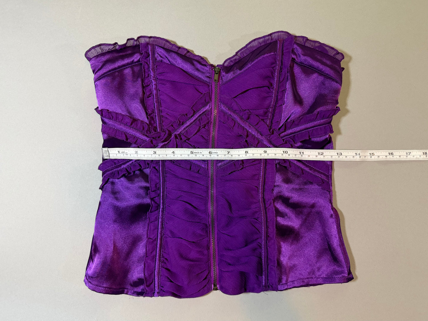 Purple satin and chiffon Bebe top with measuring tape showing 12.5 inches waist 