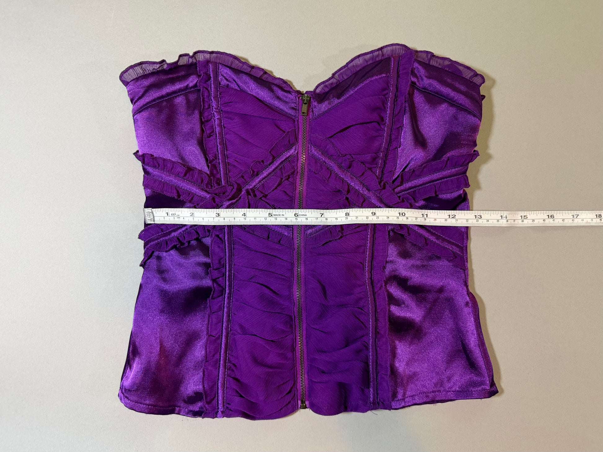 Purple satin and chiffon Bebe top with measuring tape showing 12.5 inches waist 