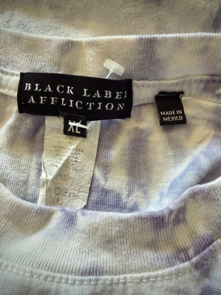 Close up of “Black Label” Affliction neck tag and size tag showing extra large. Another small tag shows made in Mexico. 