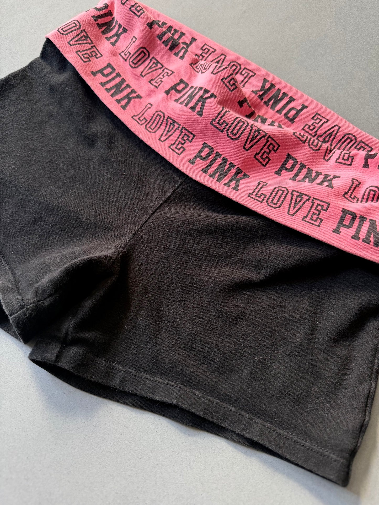 Angled of y2k Victoria’s Secret PINK yoga shorts with pink foldover waistband 
