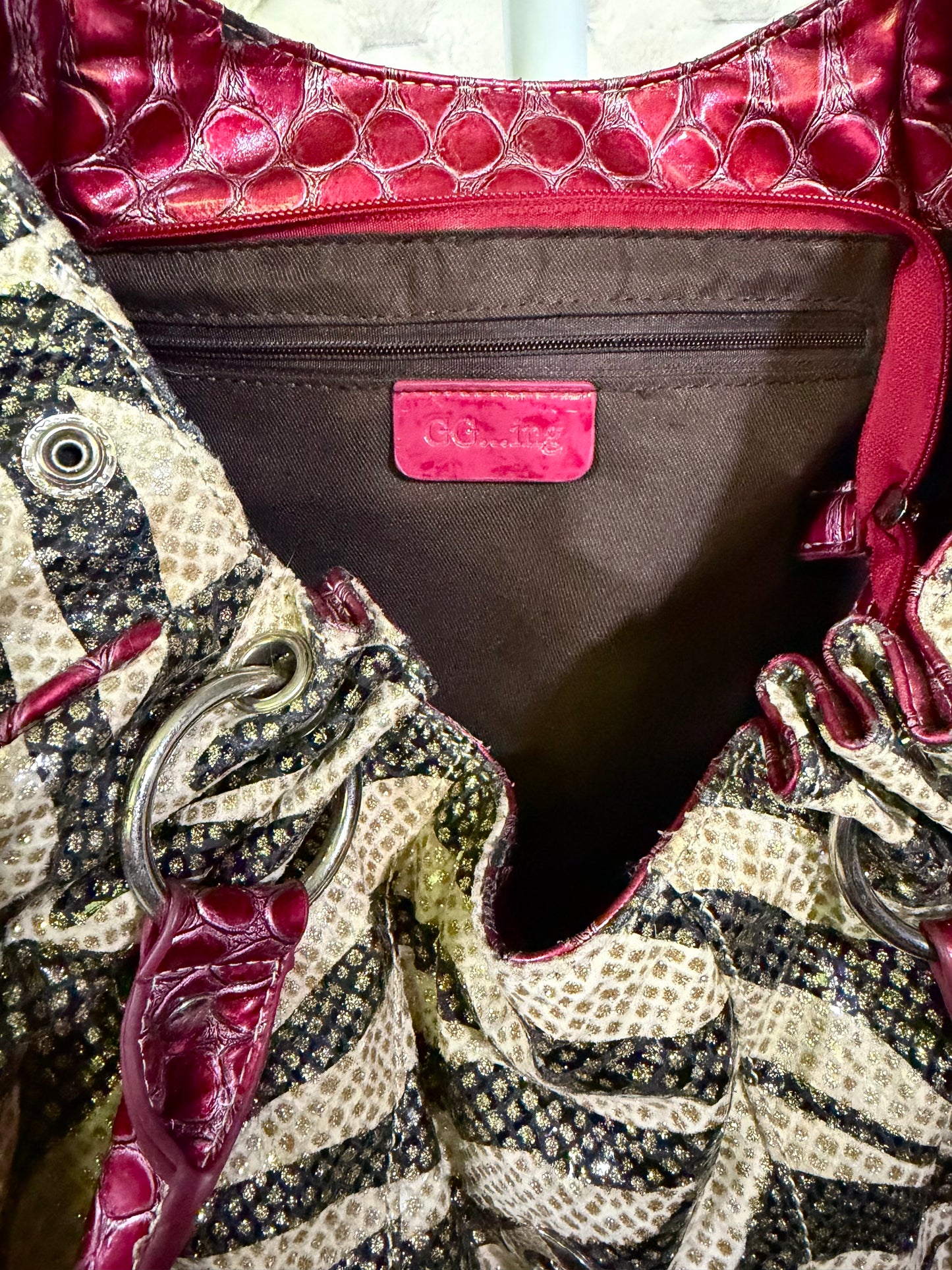 Interior brand label and compartment details of zebra print hobo handbag