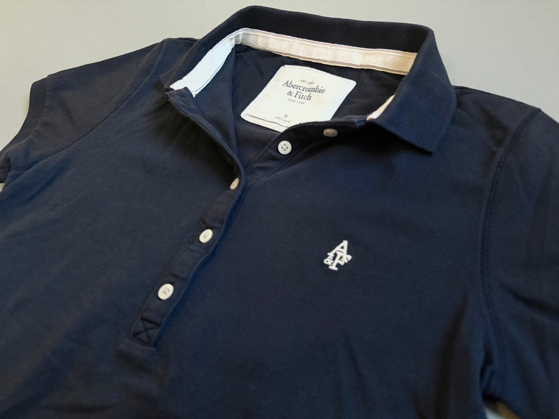 Close up of Abercrombie & Fitch polo collar and embroidered branding 