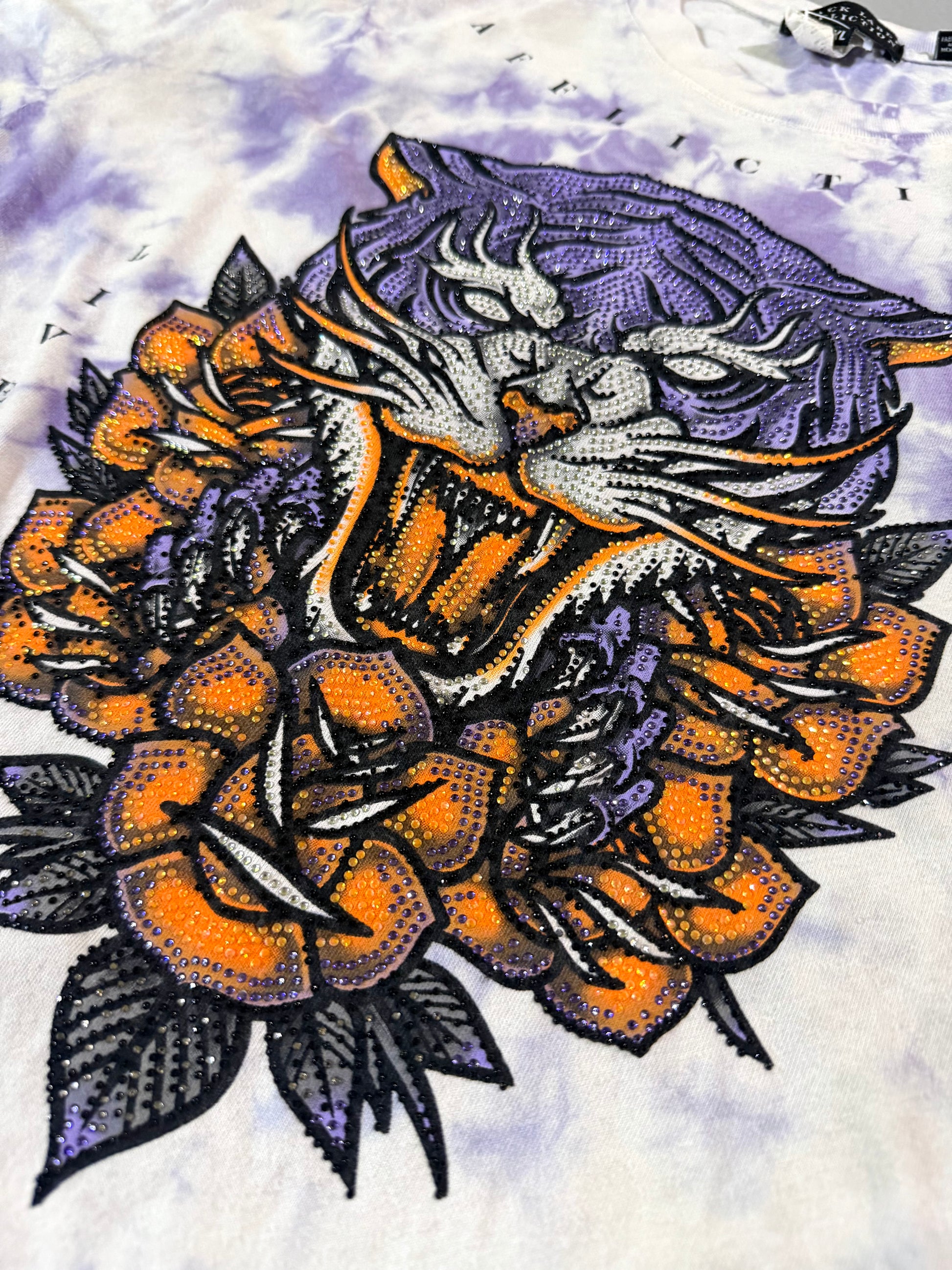 Close-up of the rhinestone-embellished roaring tiger and orange rose graphic on the Affliction Black Label T-shirt.