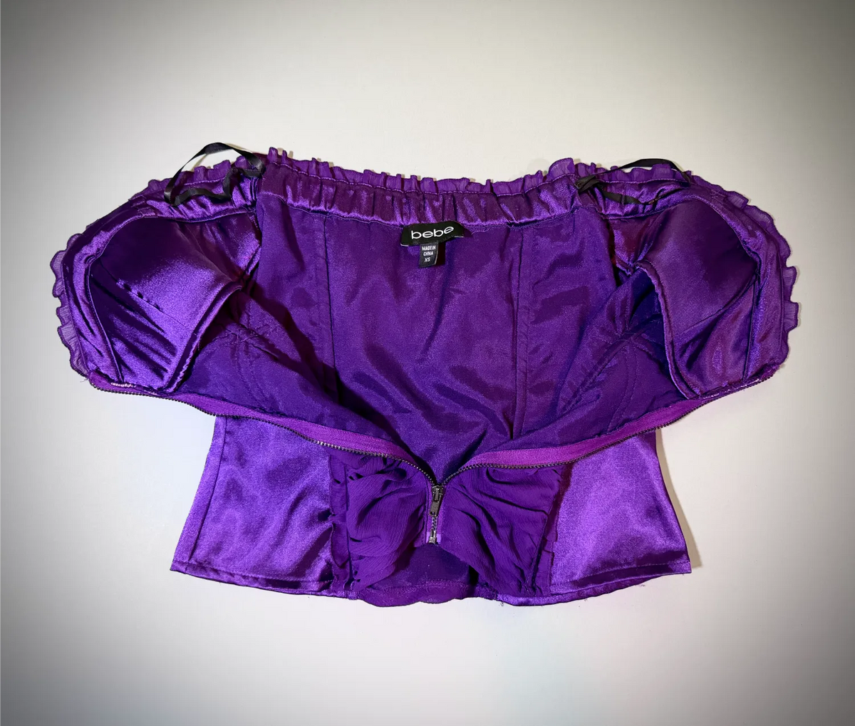 Front of Bebe top with middle zipper opened to show inside lining 