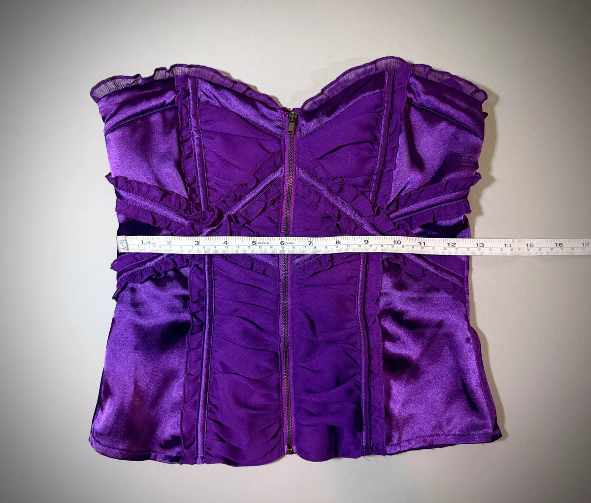 Purple satin and chiffon Bebe top with measuring tape showing 12.5 inches waist 