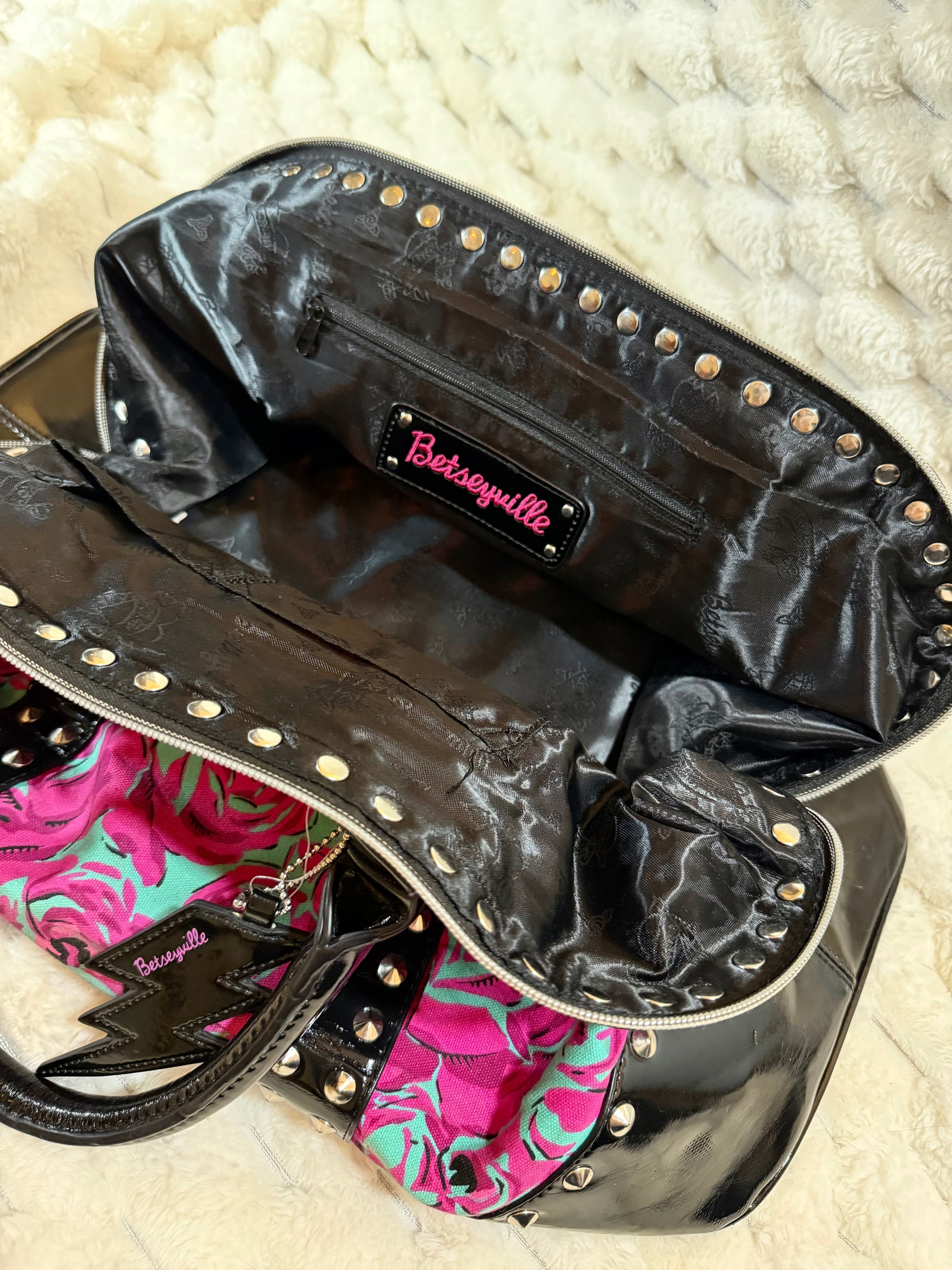 Interior of the Betseyville satchel with black logo lining, zip pocket, and spacious main compartment.