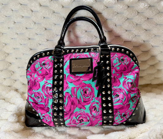 Betseyville by Betsey Johnson floral duffel featuring vibrant pink roses, turquoise background, black patent trim, silver studs, and lightning bolt charm.