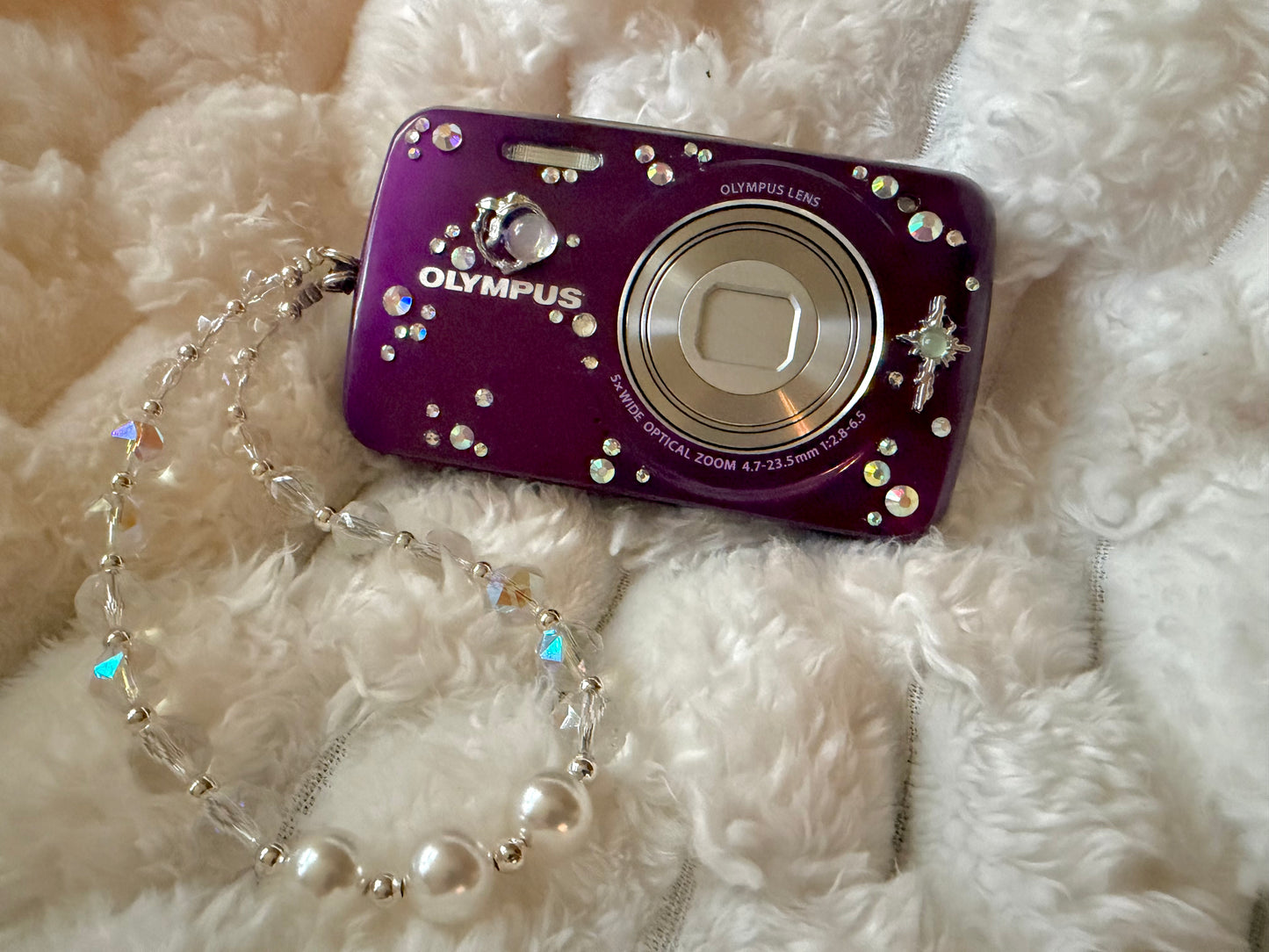 Purple Olympus digital camera decorated with rhinestones and celestial charms 