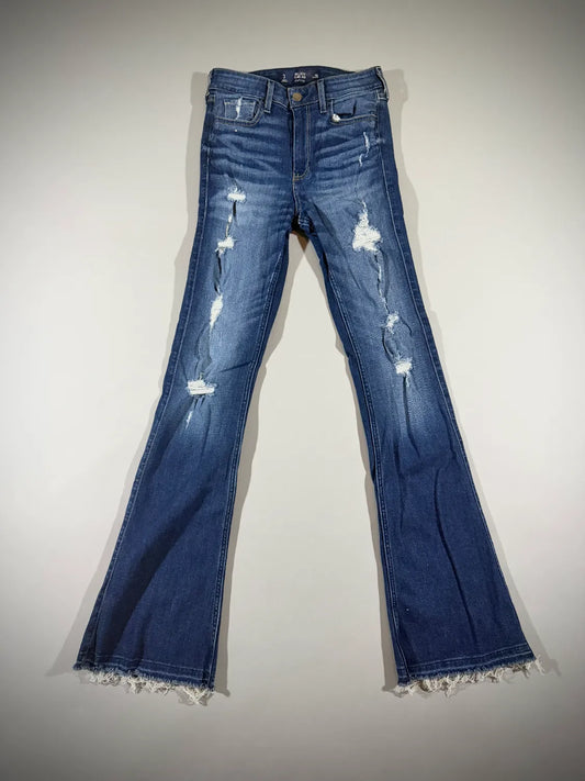 2010 Hollister high-rise flare jeans in medium wash with distressed knees and raw frayed hems shown from the front.