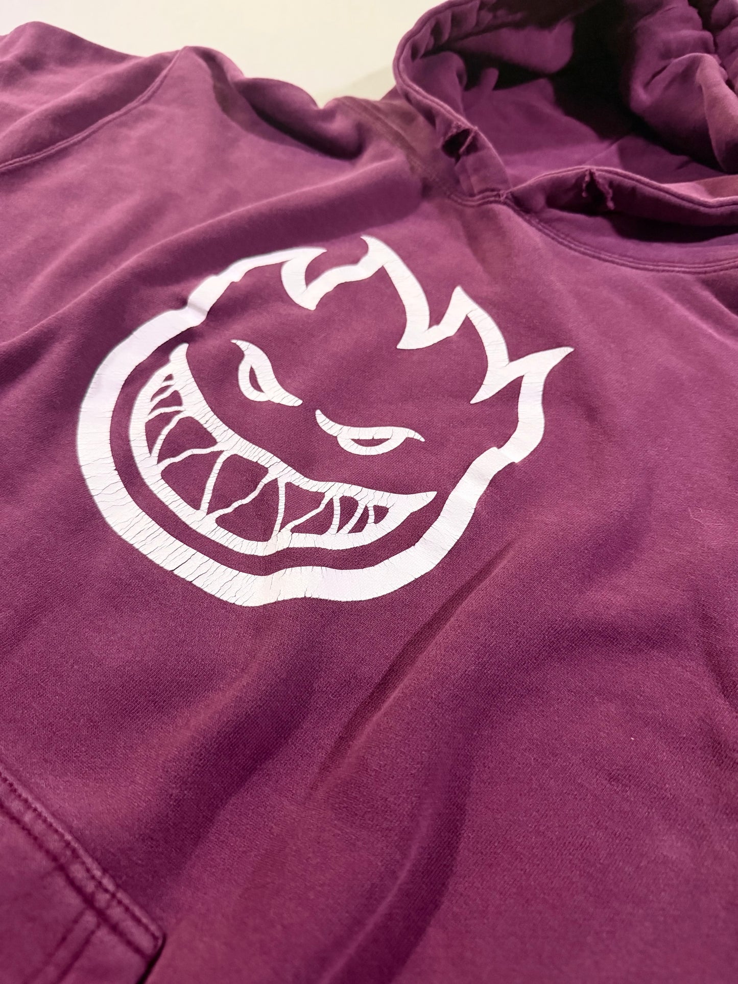 Close-up of the cracked Spitfire Bighead graphic on faded plum heavyweight hoodie.