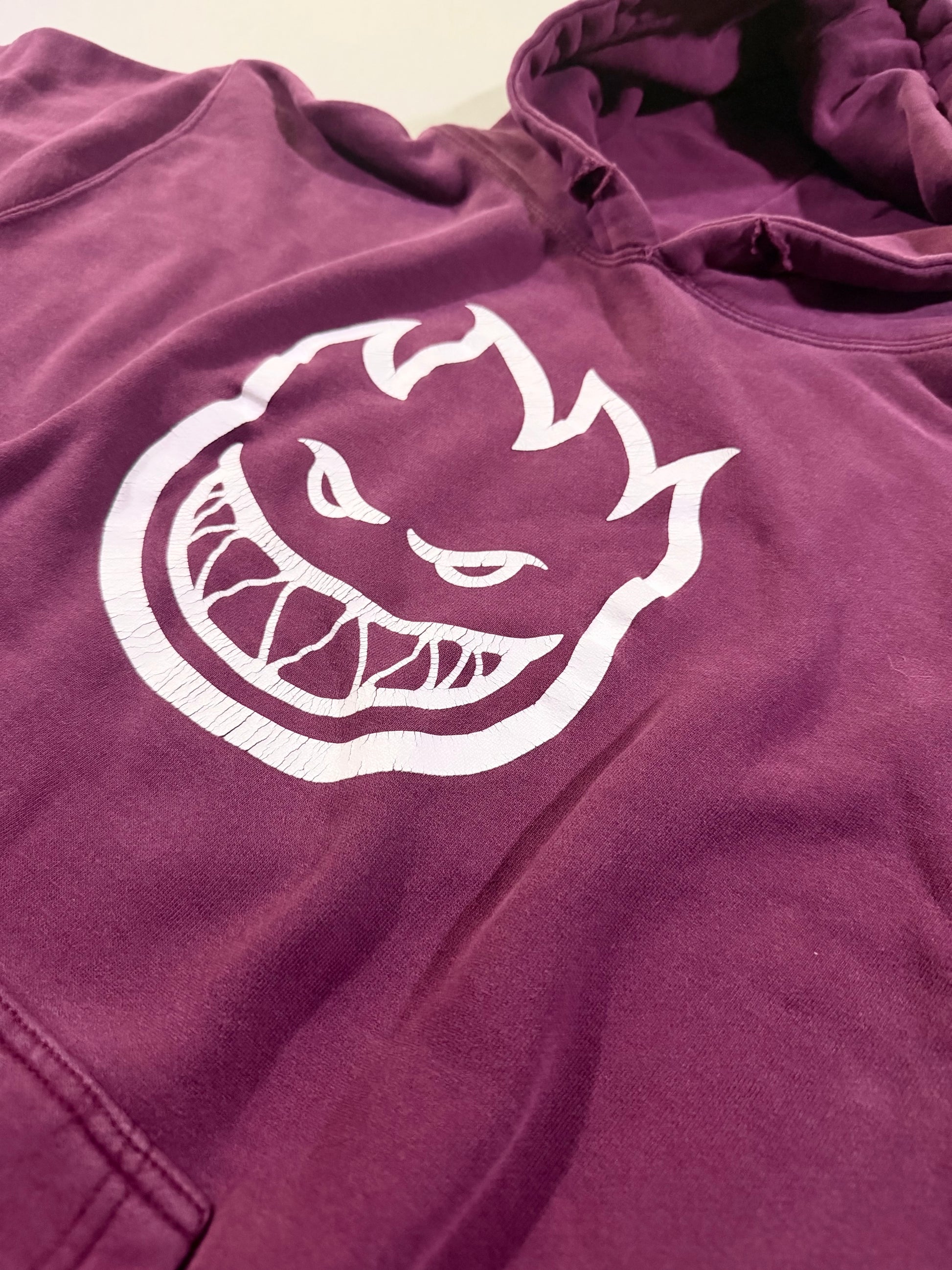Close-up of the cracked Spitfire Bighead graphic on faded plum heavyweight hoodie.