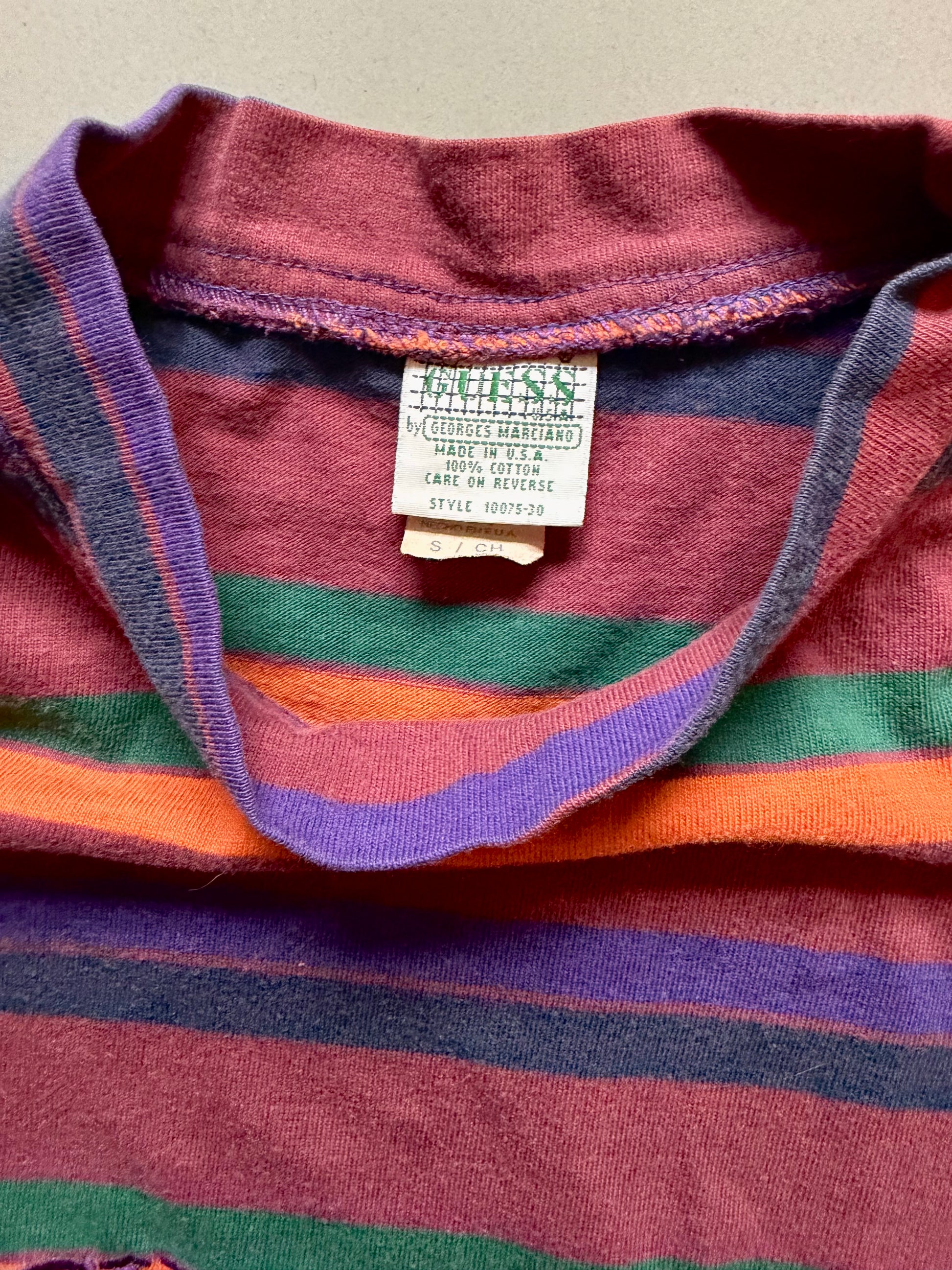 Close-up of vintage 90s striped Guess t-shirt label, style and care tag. 