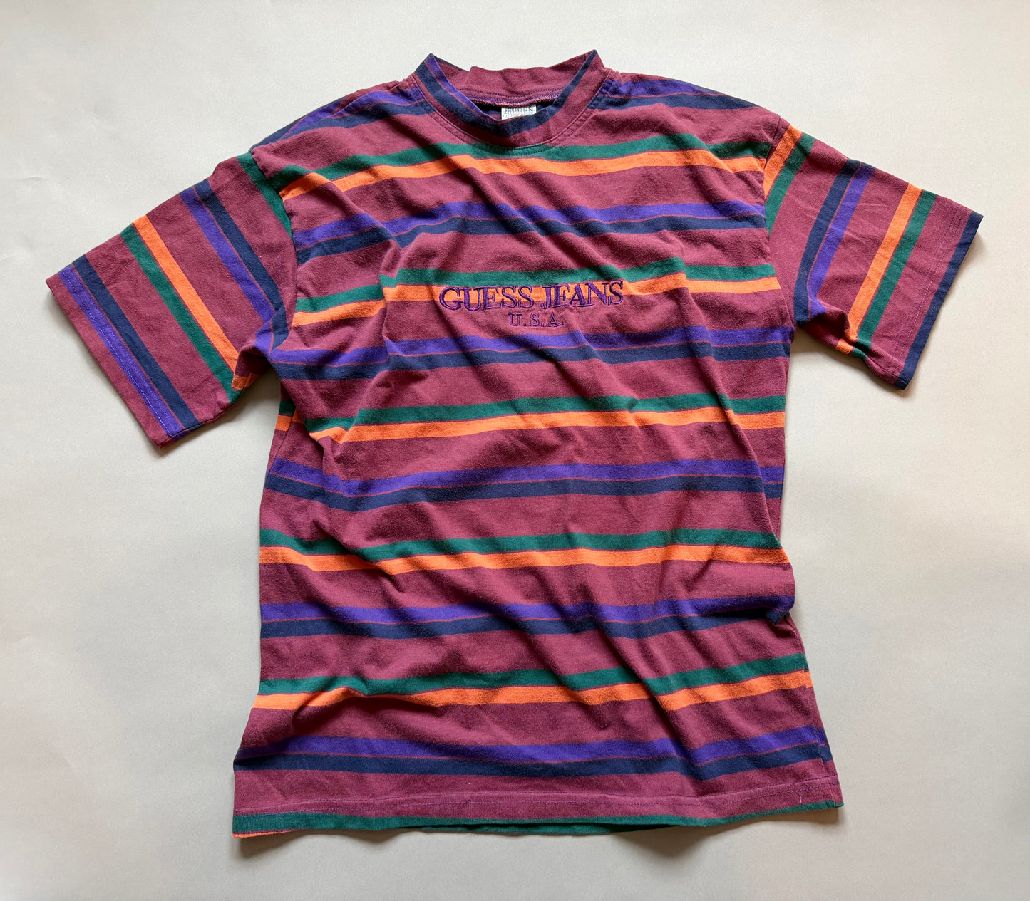 Striped t-shirt with Guess Jeans logo on a light gray background