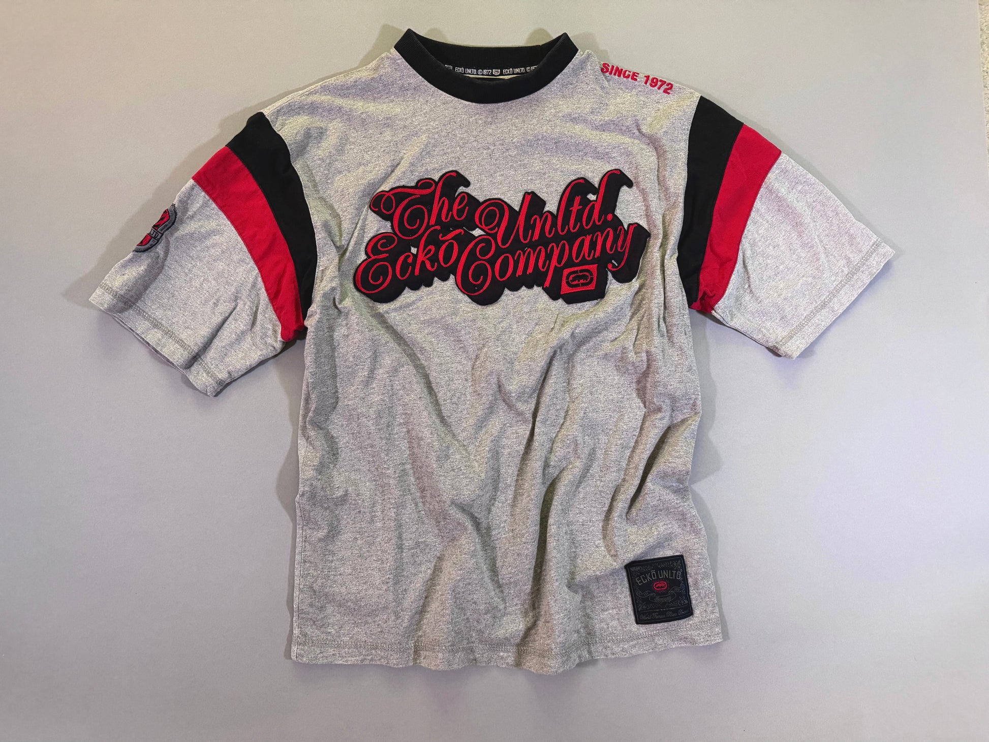 Y2K Ecko Unltd tee with cursive embroidered branding, jock tag, and color block sleeves 