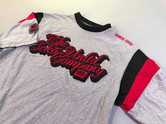 Angled photo of 2000s era Ecko Unltd tee with embroidered cursive branding and colorblock sleeves 
