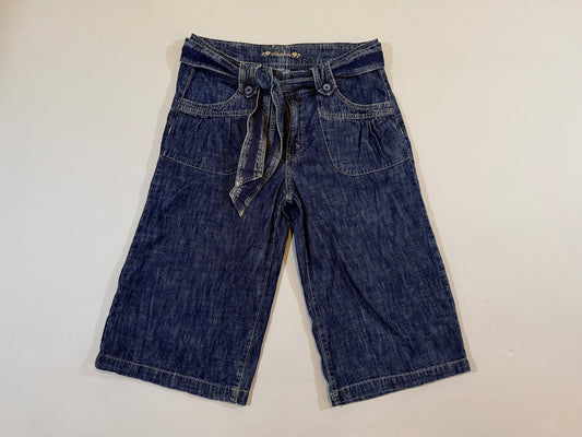Vintage dark wash denim cropped longline pants with removable self-tie belt and wide-leg silhouette laid flat.
