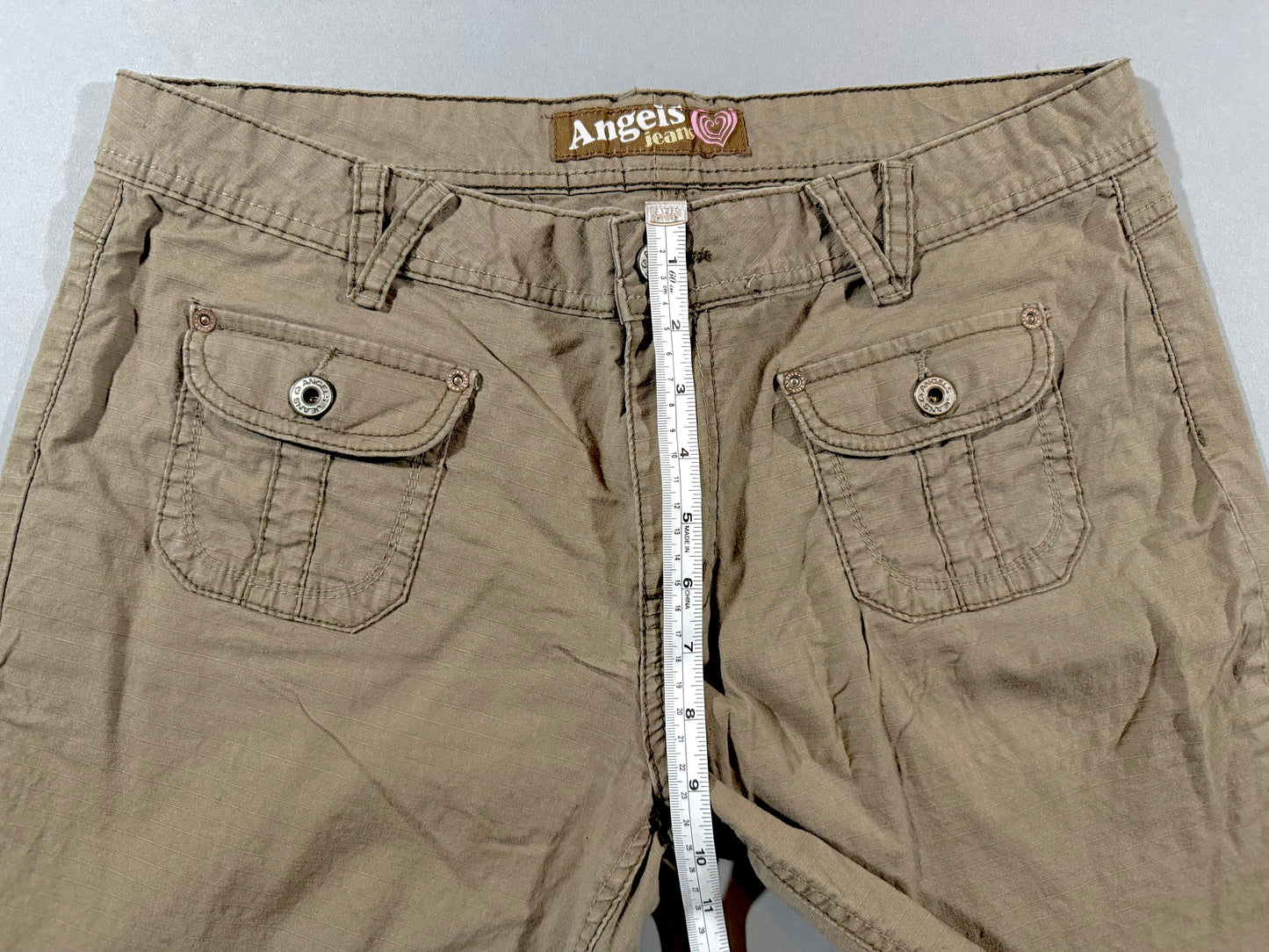 Close-up of front rise measurement, waistband, and pocket details on Angels Jeans capri pants.