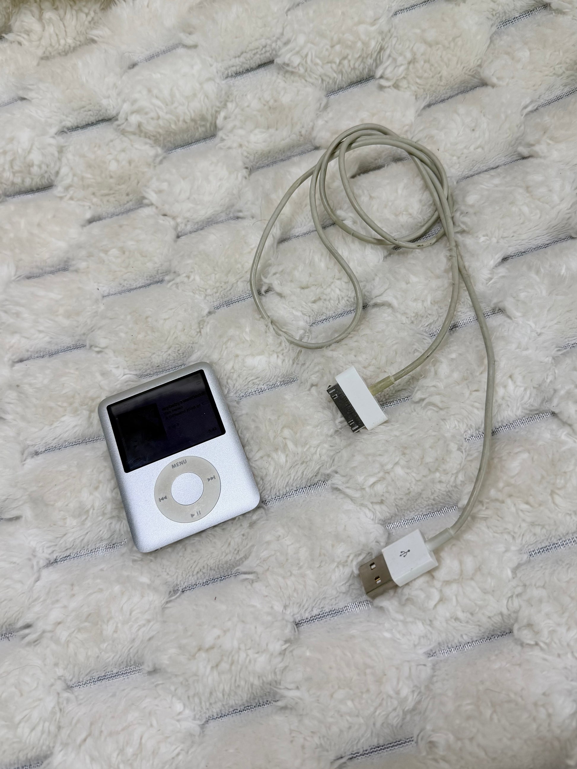 Silver Apple iPod nano 3rd generation with original-style 30-pin USB charging and sync cable.