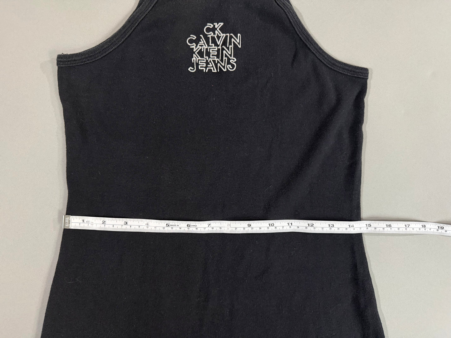 Waist measurement of fitted Calvin Klein Jeans black Y2K dress.