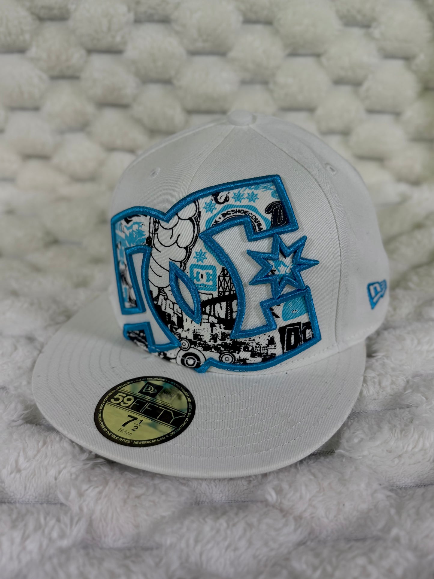 Angled view of vintage DC Shoes 59FIFTY fitted hat showing oversized graphic logo, flat brim and blue New Era side embroidery.