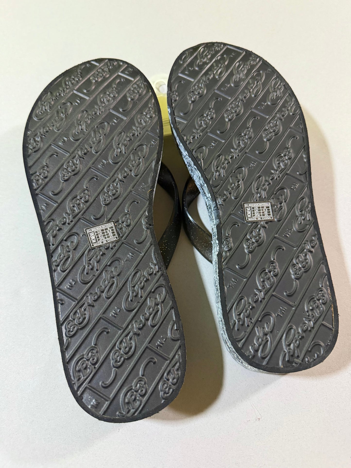 Bottom soles of Ed Hardy platform flip-flops showing clean, unworn condition, branded tread and women’s size 9 labels.