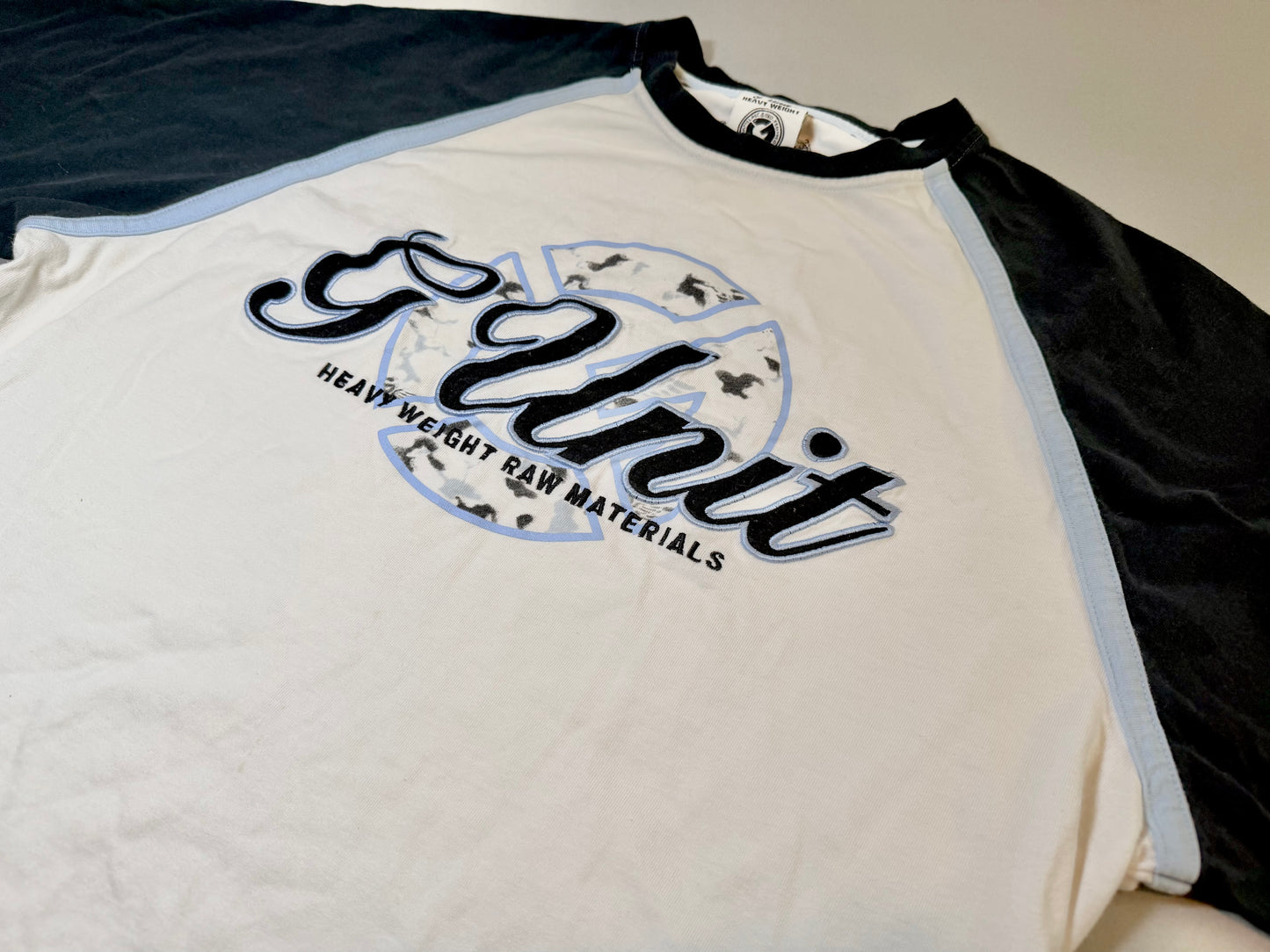 Close-up of the embroidered G-Unit chest graphic with Heavy Weight Raw Materials branding.